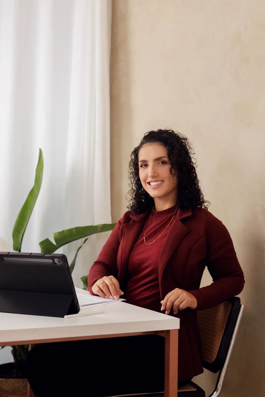 Alyne no escritório, analisando projetos e trabalhando com um tablet